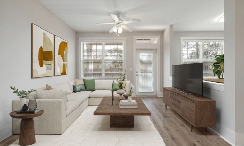 Spacious Modern Living Room A well-lit living room with contemporary furniture, a neutral color palette, and large windows allowing natural light to fill the space. The open layout connects seamlessly to the adjacent kitchen.